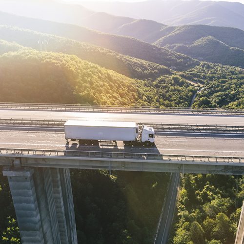 trucks on highway in mountain at sunset
