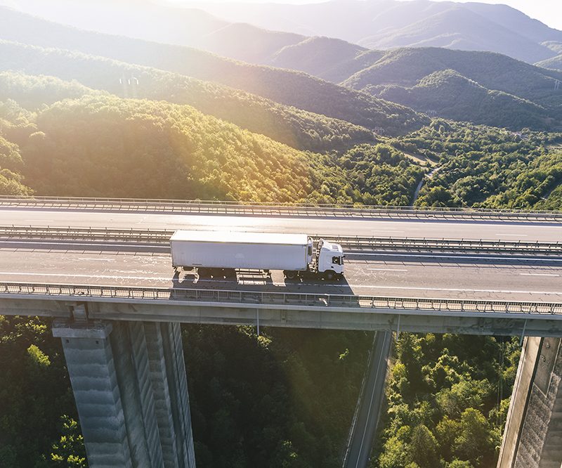 trucks on highway in mountain at sunset
